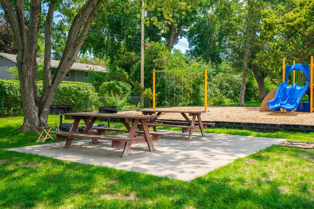 a picnic table and a playground in a park