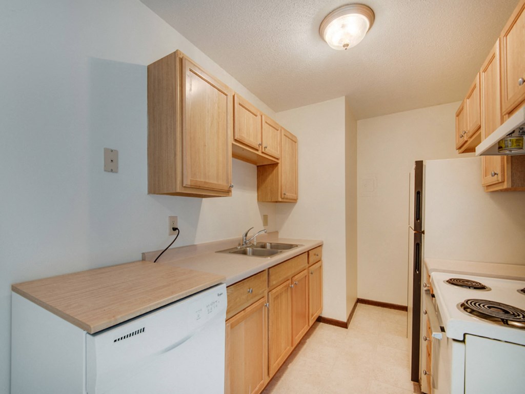 a kitchen with white appliances and wooden cabinets