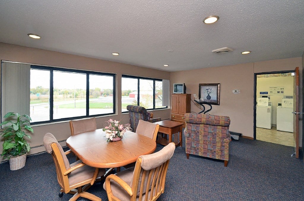 A dining room with a round table and chairs.