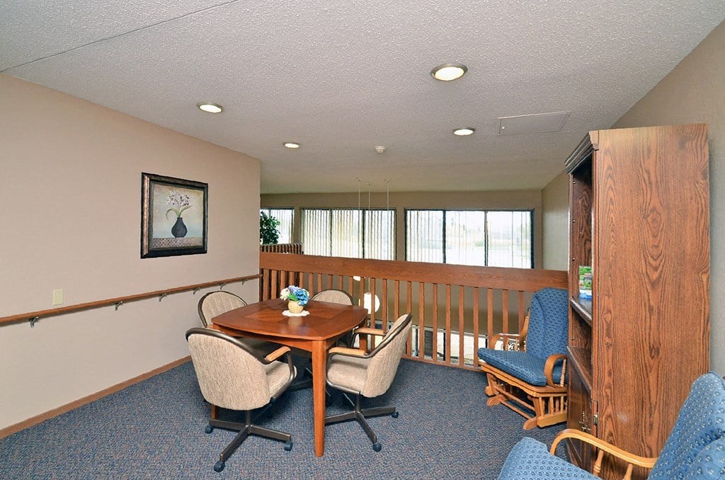 A conference room with a table, chairs, and a framed picture on the wall.