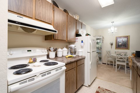 A kitchen with a white stove top oven and white refrigerator.