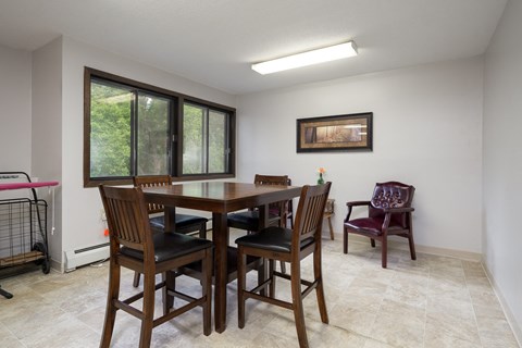 A dining room with a table and chairs.