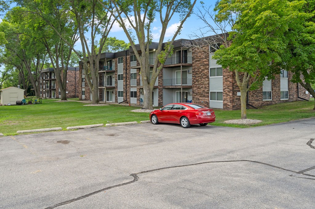 a red car parked in front of an apartment building