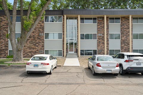 the front of a building with three cars parked in front of it