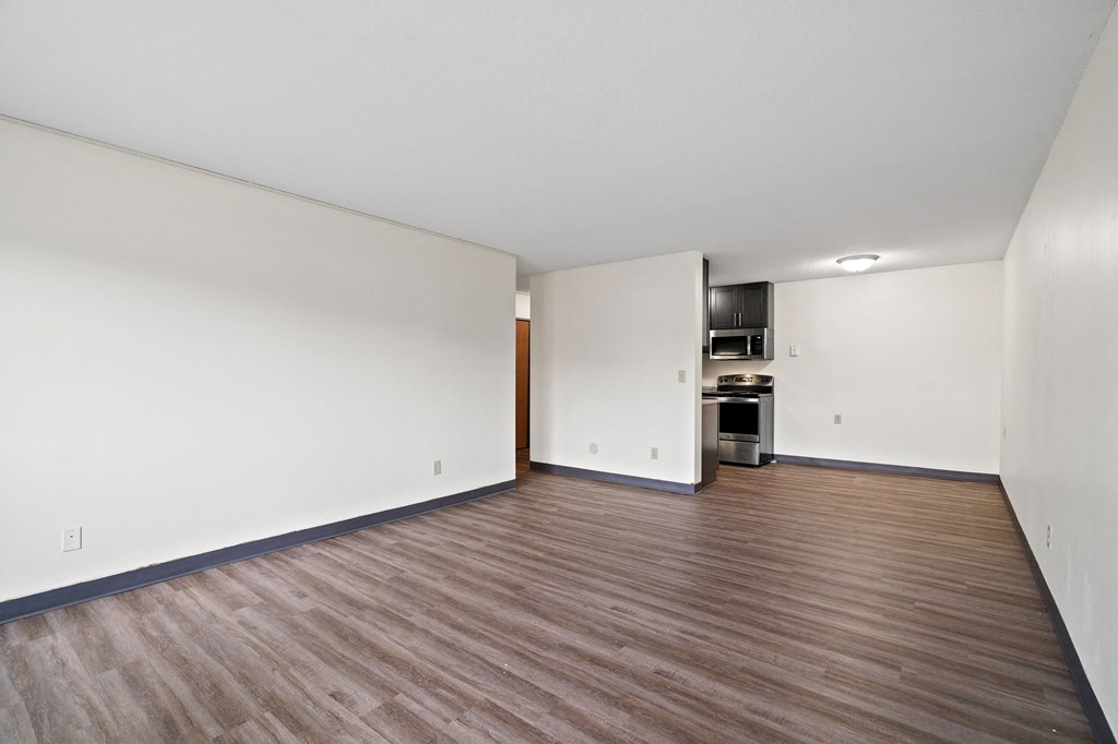 an empty living room with white walls and wood flooring