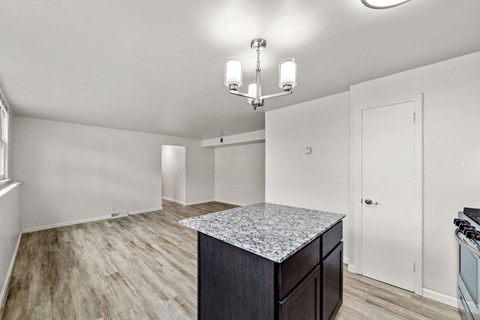 A kitchen with a granite countertop and a chandelier.