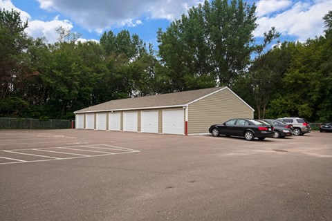 a parking lot with cars parked in front of a garage