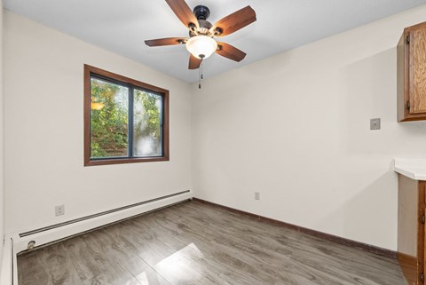 A room with a ceiling fan and a window.