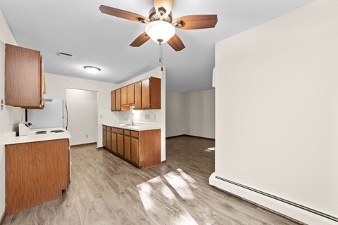 A kitchen with wooden cabinets and a ceiling fan.