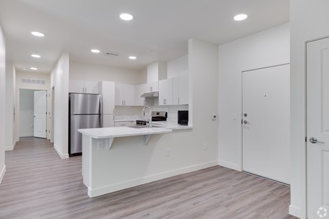 A kitchen with white cabinets and a white island.