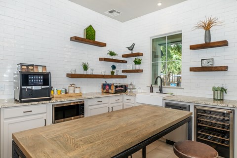 A kitchen with a wooden table and white brick walls.
