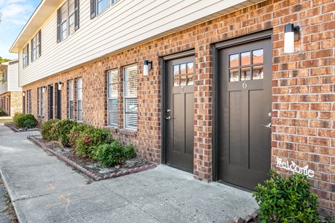 A brick building with a black door and windows.