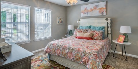 A bedroom with a large bed and a painting on the wall.