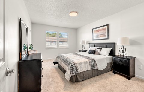 A bedroom with a large bed and a dresser.