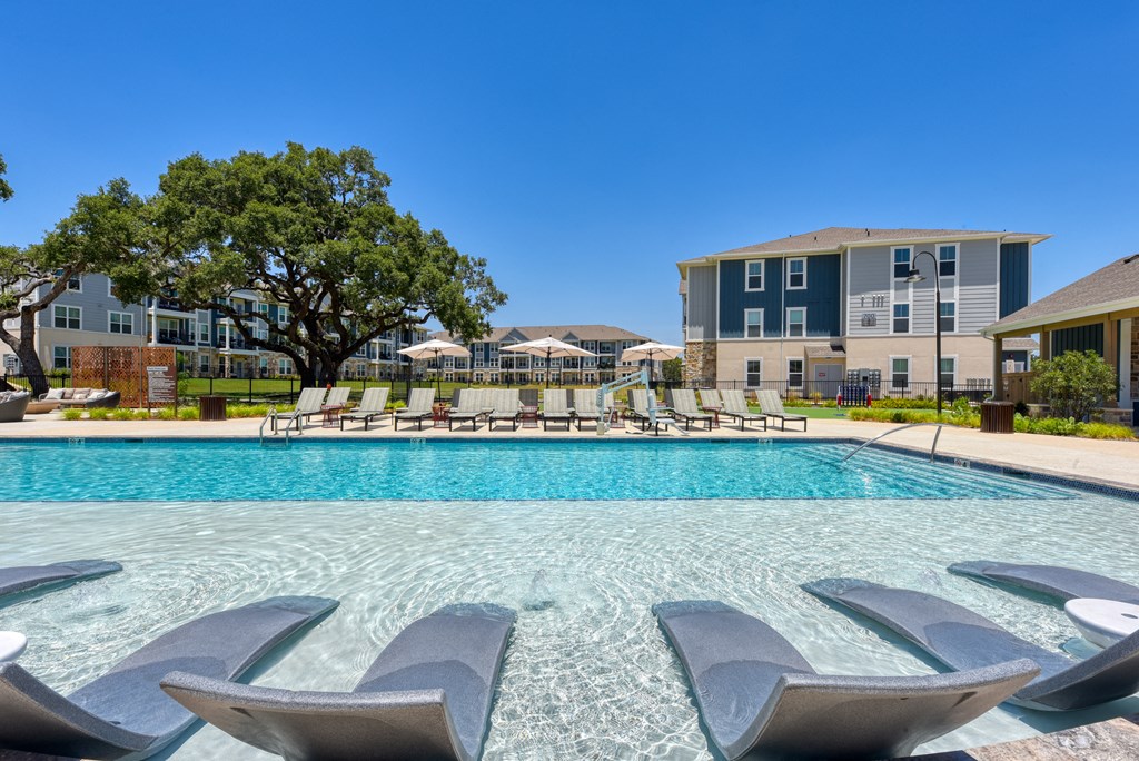 our apartments have a resort style pool with lounge chairs at Estraya Boerne, Texas