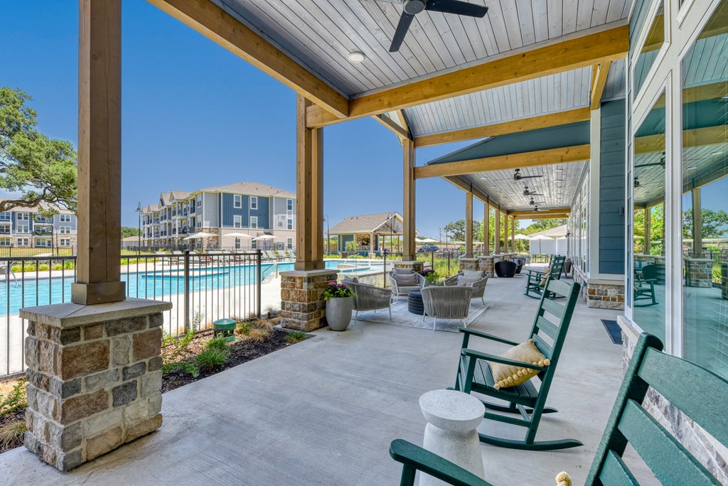 the preserve at ballantyne commons covered patio with chairs and a pool at Estraya Boerne, Texas