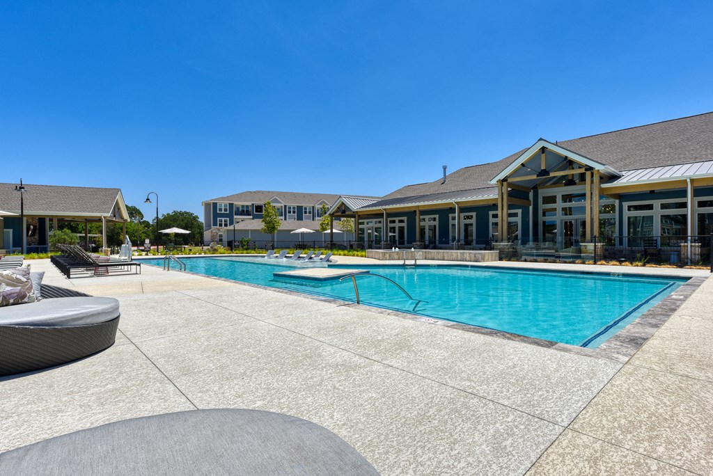 a swimming pool with a building in the background at Estraya Boerne, Texas, 78006