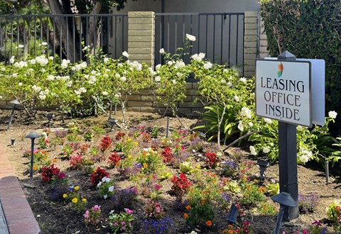 A garden with a sign that says Leasing Office Inside.