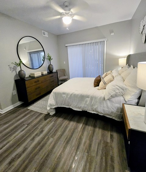 A bedroom with a large bed and a dresser with a mirror.