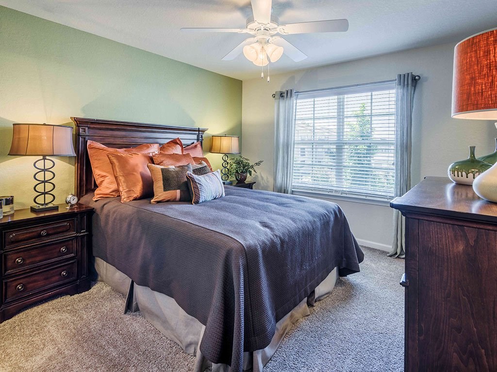 a bedroom with a bed and a ceiling fan