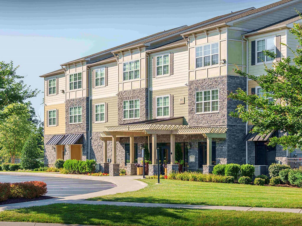 an exterior view of a building with a sidewalk and grass