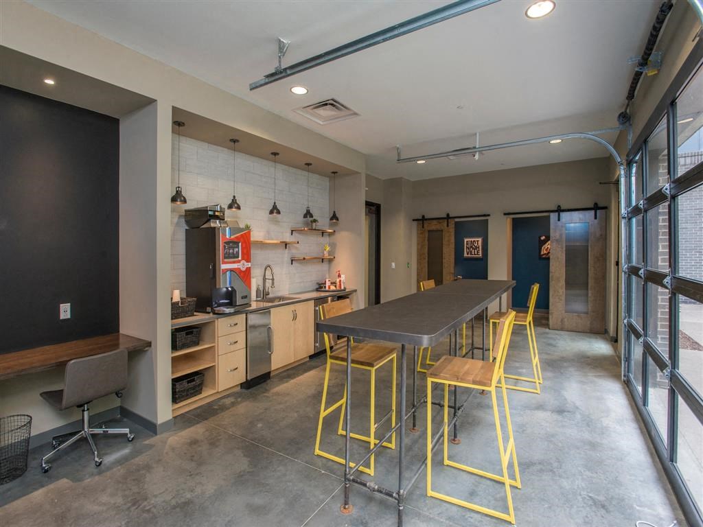 a kitchen and dining area in a room with a table and chairs