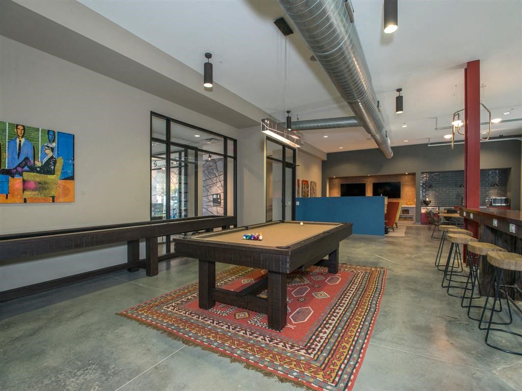 a pool table in a room with a bar and tables