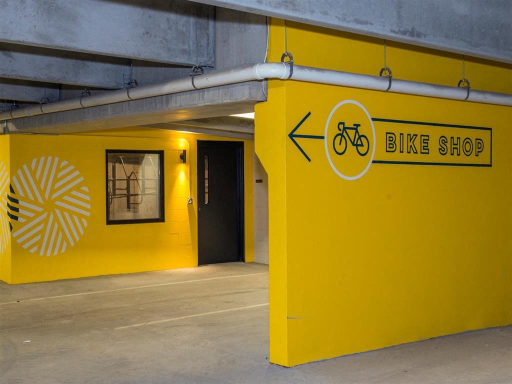 a bike shop is painted yellow in a parking garage
