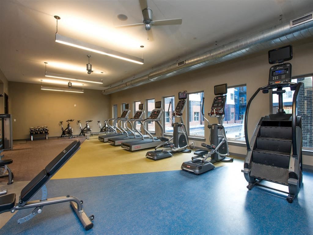 a gym with cardio equipment and weights