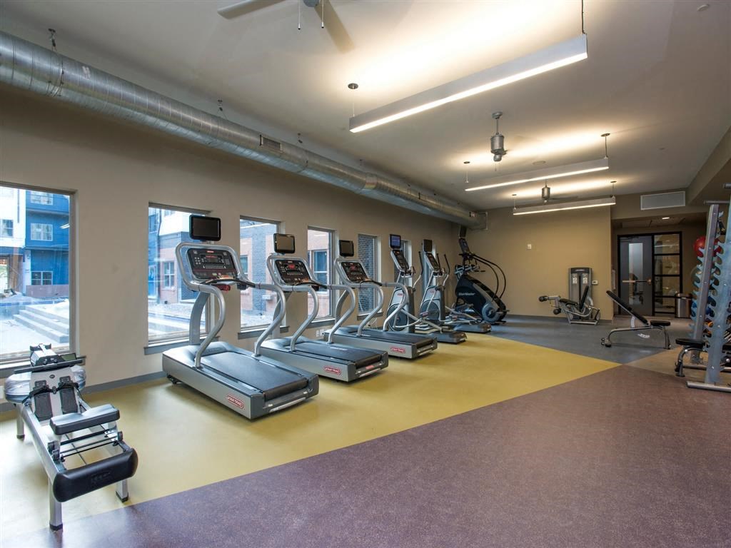 a gym with cardio equipment and weights in a building
