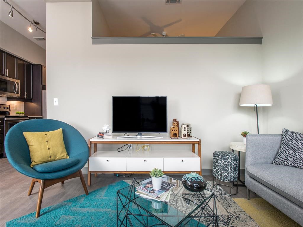a living room with a blue chair and a television