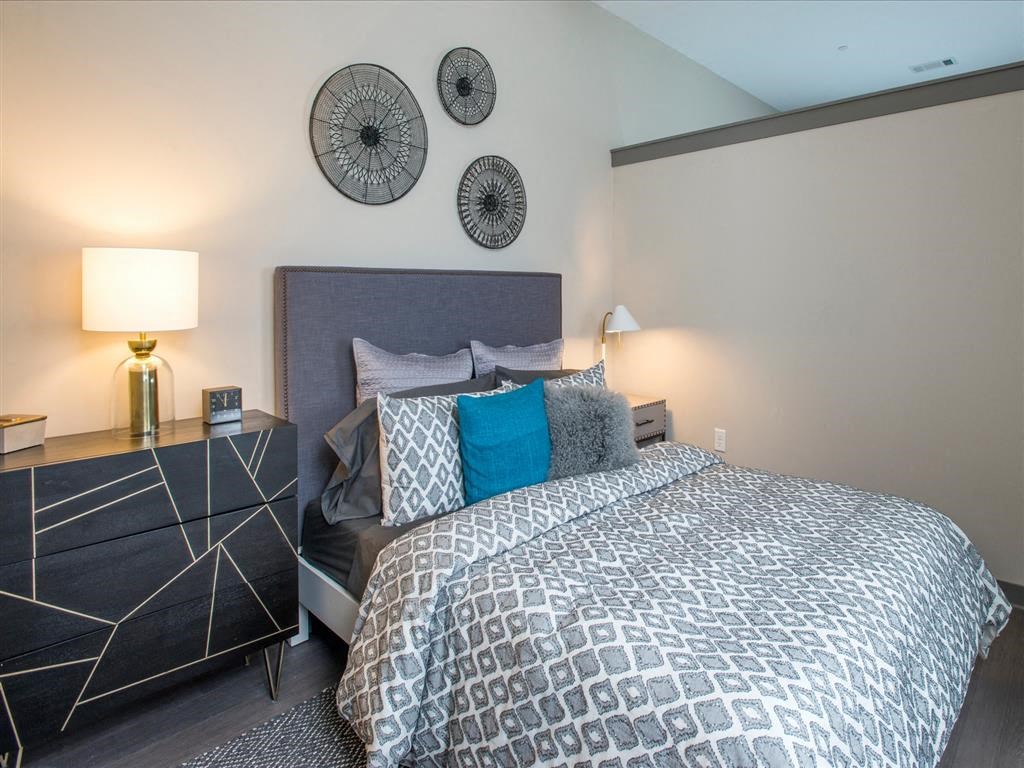 a bedroom with a bed and two clocks on the wall