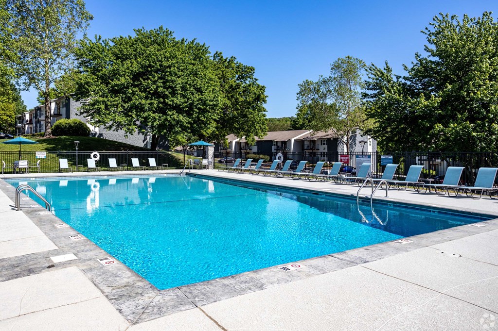 A large swimming pool surrounded by trees and lounge chairs.at Addison at Sutherland, Knoxville, TN 37909  