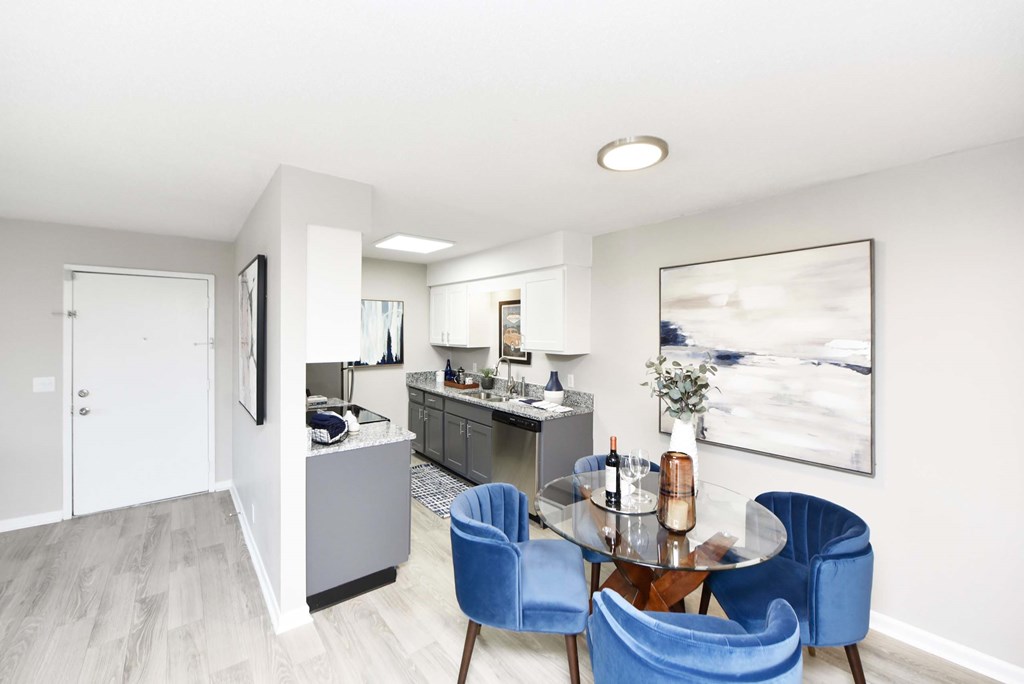 A modern kitchen with a dining table and blue chairs.at Addison at Sutherland, Knoxville, TN  