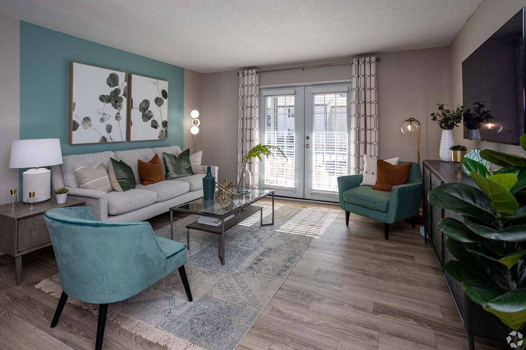 A living room with a couch, chair, and potted plant.at Addison at Sutherland, Knoxville, TN 37909  