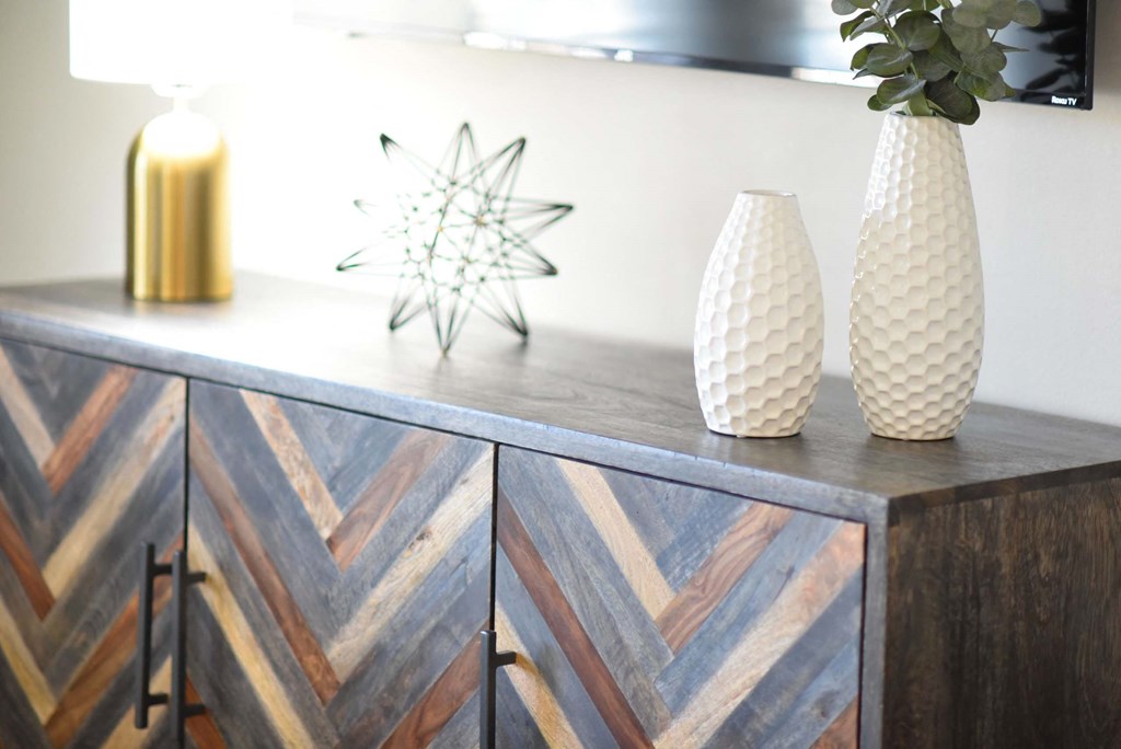 A wooden cabinet with a chevron pattern and two vases on top.at Addison at Sutherland, Knoxville, TN 37909  