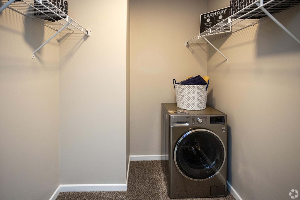 A laundry room with a washer and dryer and a basket on top of the dryer.at Addison at Sutherland, Tennessee, 37909