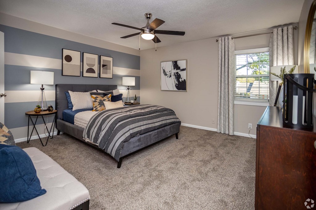 A bedroom with a bed, a ceiling fan, and a nightstand.at Addison at Sutherland, Knoxville, TN  