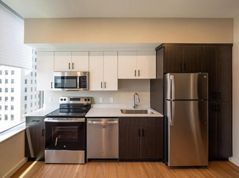 A modern kitchen with stainless steel appliances and wooden cabinets.