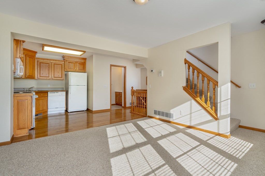 A spacious living room with a staircase leading to the upper floor.