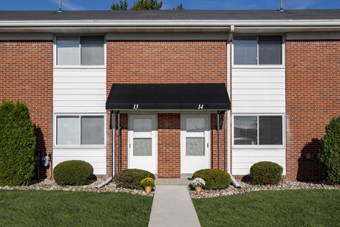 A brick building with a white door and windows.
