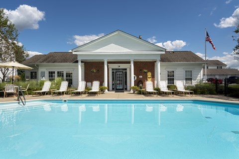 A white house with a pool in front.