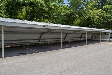 A long metal carport with a grey roof and pillars.