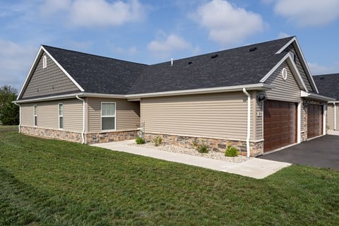 A house with a garage and a stone wall.