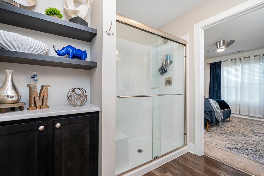 A glass door is in the middle of a black cabinet.