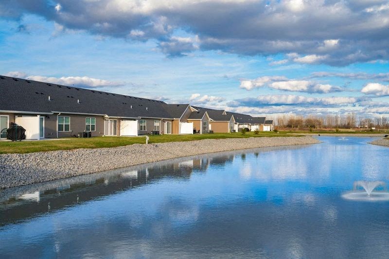 A row of houses with a body of water in front of them.