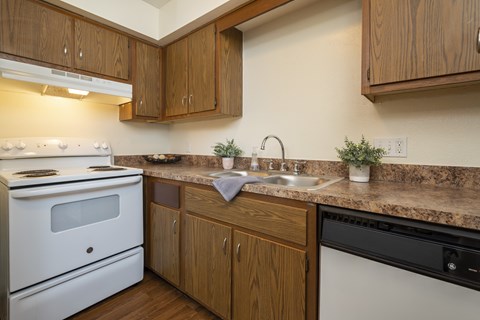 A kitchen with a white stove and wooden cabinets.