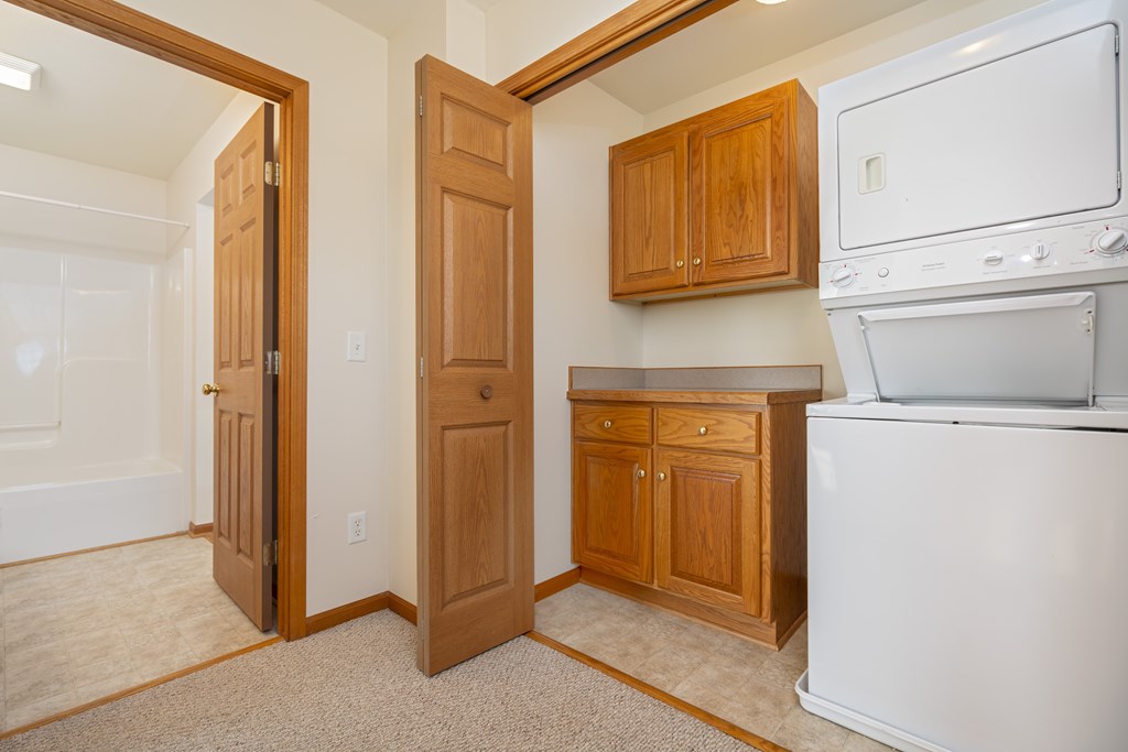 A white oven and dishwasher in a kitchen with wooden cabinets.