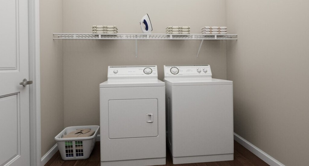 Two white front loading washing machines in a laundry room.