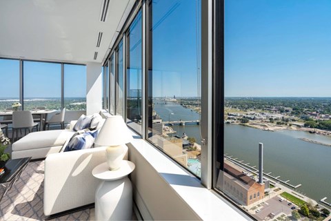 A modern living room with a view of a river and a cityscape.